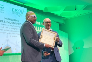 Minister of Tourism, Hon. Edmund Bartlett (L) collects his ITIC award for his work in Sustainability and Resilience in Tourism at the ITIC Global Tourism Summit on Monday, November 4, from Ibrahim Ayoub, Group CEO, MD and Board Member of International Tourism Investment Corporation Ltd. 