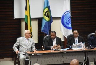Justice Minister, Hon. Delroy Chuck (left), speaks during the CCJ Academy for Law regional townhall at the University of the West Indies, Mona Campus, on Thursday (November 14). The hybrid session focused on advancing justice in the Caribbean, post Needham’s Point Declaration. Listening are: Senior Deputy Director of Public Prosecutions, Jeremy Taylor, KC (centre), and Attorney-at-law, Peter Champagnie, KC.