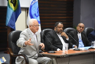 Minister of Justice, Hon. Delroy Chuck (left), addresses the CCJ Academy for Law regional townhall at the University of the West Indies, Mona Campus, on Thursday (November 14). The hybrid session focused on advancing justice in the Caribbean, post Needham’s Point Declaration. Listening (from second left) are: Senior Deputy Director of Public Prosecutions, Jeremy Taylor, KC, and Attorney-at-law, Peter Champagnie, KC.


