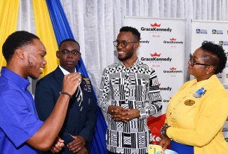 Chairperson of the National Child Month Committee (NCMC), Nicole Patrick-Shaw (right), listens to a point from JN Ambassador, Bradwell McLeod (left), during Friday’s (Nov. 1) NCMC Youth Forum at the Caenwood Centre in Kingston. Sharing in the conversation are Jamaica College student, Lejoux Choung (second left) and Director of the African Caribbean Institute of Jamaica, Dr. Kirt Henry.