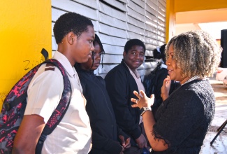 Minister of Education, Skills, Youth and Information, Senator Dr. the Hon. Dana Morris Dixon (right), speaks with grade eight students at Holmwood Technical High School in Manchester, during a recent visit to the institution. Pictured (from left) are Jawanza Russell, Jaroni Dixon and Jordayne Nunes. 