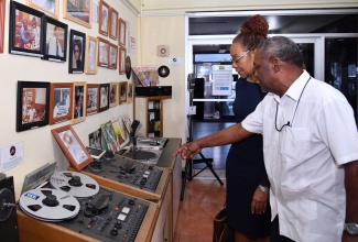 Chief Executive Officer of the Public Broadcasting Corporation of Jamaica (PBCJ), Keith Campbell, and PBCJ Board Chair, Rose Bennett-Cooper, view an exhibition chronicling 100 years of Jamaica’s audiovisual history at PBCJ’s South Odeon Avenue offices in Kingston on Tuesday (November 12). The exhibition, which was launched on Tuesday, runs until the end of November.