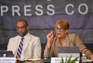 Deputy Governor of the Bank of Jamaica (BOJ) with responsibility for Financial Markets and Payments Systems, Natalie Haynes (right), addresses concerns regarding shortage of coins and certain banknotes in the financial system, at the Central Bank’s Quarterly Monetary Policy Report Press Conference, on Monday (November 25). Listening is Senior Deputy Governor of the Bank of Jamaica, Wayne Robinson. 
