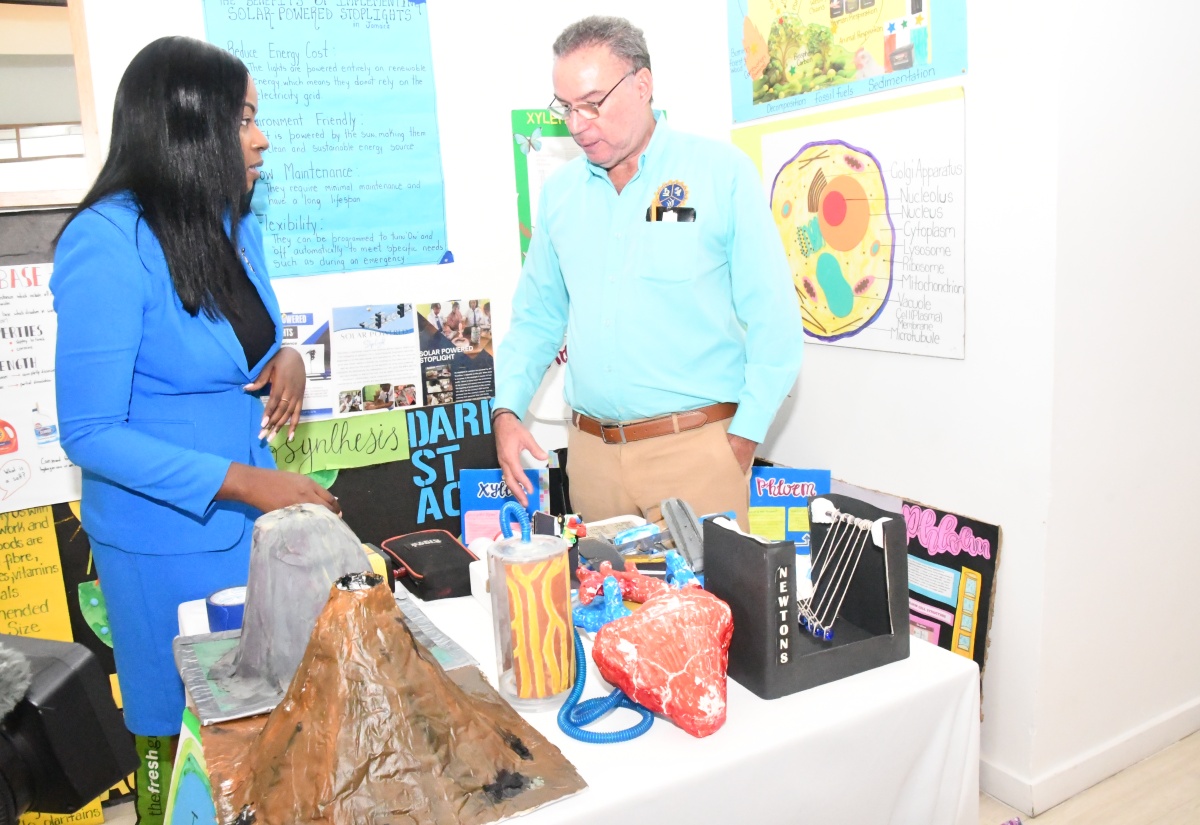 Minister of Science, Energy, Telecommunications and Transport, Hon. Daryl Vaz, listens as Senior Teacher at Immaculate Conception High School in St. Andrew, Kadesha Croney, highlights science projects on display during the annual conference of the Association of Science Teachers of Jamaica (ASTJ) at the Bahia Principe Resort in Runaway Bay, St. Ann, on November 13.