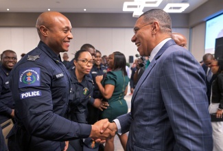 Prime Minister, Dr. the Most Hon. Andrew Holness (right), congratulates Sergeant Fitzroy Rochester during Tuesday’s (November 12) graduation ceremony for the second cohort of participants in the Jamaica Constabulary Force’s (JCF) Inspector Development Course, at the AC Hotel by Marriott Kingston. A total of 99 persons participated in the course.