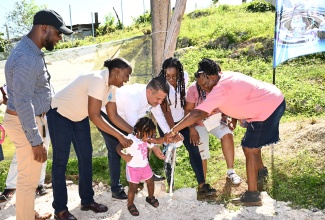 Minister without Portfolio in the Ministry of Economic Growth and Job Creation, Hon. Matthew Samuda (third left), gets assistance from little Nicolette Minto in turning on the tap to officially commission into service the $35 million Spicy Hill Pipeline Project in Trelawny on Tuesday (December 17). Sharing the moment (from left) are: National Water Commission (NWC) Regional Manager for Trelawny and St. James, Herman Fagan; Acting Vice President of Operations at NWC, Dr. Phillipa Campbell-Francis; Member of Parliament for Trelawny Northern, Tova Hamilton; and resident Velma Patterson (right).

 