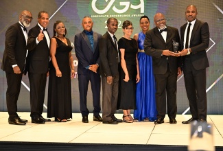 Minister of State in the Ministry of Finance and the Public Service, Hon. Zavia Mayne (right), presents the Finance Minister's award to the Factories Corporation of Jamaica (FCJ) at the Public Bodies Corporate Governance Awards ceremony on Wednesday (December 4) at The Jamaica Pegasus hotel in New Kingston. Accepting the award (from left) are Managing Director, Dr. Donald Farquharson; Board Chairman, Lyttleton Shirley; Corporate/Company Secretary, Dirkette Cooper; and board members Michael Stern, Kirk Benjamin, Danya Ho, Rochelle Cameron and Dr. Kofi Nkrumah-Young.

