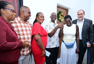 Minister of Local Government and Community Development, Hon. Desmond McKenzie (fourth left), presents keys to Ellenor Whyte (second right), of Beresford Street in St. Andrew South, for her new home which was built under the Indigent Housing Programme. The unit was handed over on December. 16. Sharing the moment (from left) are: Permanent Secretary in the Ministry, Marsha Martin Henry; Mayor of Kingston, Andrew Swaby; Councillor for the Admiral Town Division, Louise Newland; and Member of Parliament, St. Andrew South and Leader of the Opposition, Mark Golding.