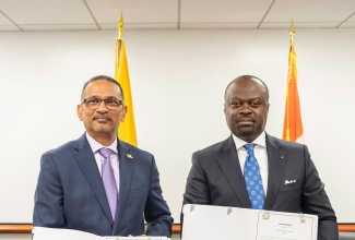 Ambassadors Brian Wallace of Jamaica (left) and Tiémoko Moriko of the Republic of Côte d’Ivoire, are pictured holding copies of the Joint Communiqué which formally established diplomatic relations between the two countries.   The document was signed in New York on December 16.

