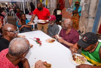 Kingston’s Mayor, Councillor Andrew Swaby (standing), serves meals to residents of the Marie Atkins Night Shelter and Desmond McKenzie Transitional Centre for the Homeless in the Corporate Area. They were treated during the Mayor’s Annual Christmas Day Feeding of the Homeless on Wednesday (December 25). The event was hosted on Water Lane in downtown Kingston.