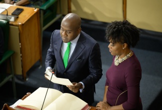 Newly elected Member of Parliament for St Andrew North Western, Duane Smith, takes the Oath of Allegiance, during the sitting of the House of Representatives on December 3. Looking on is Clerk to the Houses of Parliament, Colleen Lowe.

