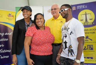 Justice Minister, Hon. Delroy Chuck (second right) and Member of Parliament for Manchester Central, Rhoda Moy Crawford (left), share a moment with visually impaired performing artistes Dr. Kimiela “Candy” Isaacs, and Nigy Boy, during the Legal Aid Council's (LAC) Justice Fair for Persons with Disabilities at Cecil Charlton Park in Mandeville, Manchester on Thursday (December 12).