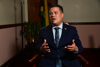 Minister without Portfolio in the Ministry of Economic Growth and Job Creation, Hon. Matthew Samuda, who has responsibility for the Environment and Water, speaks to JIS News during an interview, at his office located at 25 Dominica Drive in New Kingston on Tuesday (November 26).

