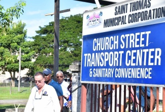 Minister of Science, Energy, Telecommunications and Transport, Hon. Daryl Vaz (foreground), tours the Church Street Transport Centre in Morant Bay, today (December 10).

