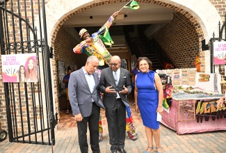 Tourism Minister, Hon. Edmund Bartlett (centre), converses with Port Authority of Jamaica (PAJ) President, Professor Gordon Shirley, during an event marking the Disney Treasure’s maiden voyage to Jamaica, at the Falmouth Cruise Port in Trelawny on Thursday (December 5). Looking on is Executive Director, Jamaica Vacations (JamVac), Joy Roberts.

