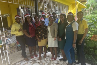 Acting Community Relations Manager at the National Water Commission's Northeast division, Ann Bolt (right), and other members of the team are all smiles at the Hill View Aged for the Home in Port Maria, St. Mary, where they donated toiletries and other necessities as well as $50,000 on December 23.