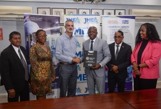 Minister of Labour and Social Security, Hon. Pearnel Charles Jr. (third right), displays the signed Memorandum of Understanding (MOU) with President of the Jamaica Manufacturers and Exporters Association (JMEA), Sydney Thwaites (third left)), to formalise the long-standing partnership between the Jamaica Productivity Centre (JPC) and the JMEA. They are joined by (from left) Board Member of the JPC, Reginald Budhan; Executive Director at the JMEA, Kamesha Turner-Blake; Minister of State in the Ministry of Labour and Social Security, Dr. the Hon. Norman Dunn and Chief Executive Officer (CEO) of the JPC, Tamar Nelson. The signing ceremony took place on Tuesday (December 10) at the Private Sector Organisation of Jamaica (PSOJ) Boardroom, 39 Old Hope Road in Kingston.