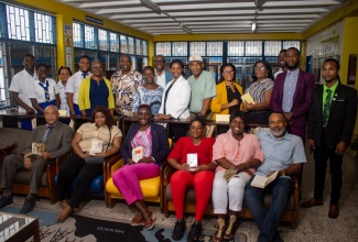 Regional Director with the Jamaica Library Service, Carrol Plummer (fifth left, standing), poses with staff, and current and past students of José Martí Technical High School in St. Catherine, during the recent handover of a $2.9-million upgraded library to the institution. The project was spearheaded by the José Martí Alumni Association New York Inc. (JMAANY), with support from various groups in the past-students association.

