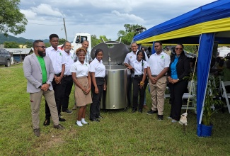 Minister of Agriculture, Fisheries and Mining, Hon. Floyd Green (fourth right), stands beside a milk machine, along with Principal of the Knockalva Polytechnic College, Natalie Wallace-Thompson (right); Chief Executive Officer of the Jamaica Dairy Development Board, Devon Sayers (left), and other persons, during the launch of the Dairy Livestock Innovation, Nutrition, Knowledge Programme (D-LINK), held at the College on November 28.

