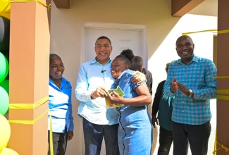 Prime Minister, Dr. the Most Andrew Holness (second left), hands a beaming New Social Housing Programme (NSHP) beneficiary, Simone Reid (third left), the keys to her new home during a handover ceremony, held in John Reid, St. Ann, on December 12. Sharing the moment are (from left): Principal Financial Officer in the Ministry of Economic Growth and Job Creation, Judith Robb Walters, and Minister of State in the Ministry of Finance and Public Service and Member of Parliament for  St. Ann South West, Hon. Zavia Mayne. Partially hidden are  Councillor of the Gibraltar Division, Cordell Wickham and Councillor of the Borobridge Division, Marline Thompson Kenyon.