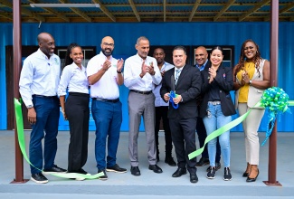 Minister without portfolio in the Ministry of Economic Growth and Job Creation, Hon. Matthew Samuda (fourth right), cuts the ribbon to open the Recycling Partners of Jamaica (RPJ) Kingsland Plastic Recycling Depot in Manchester on Thursday (December 5). Celebrating the moment are Executive Chairman of RPJ, Dr. Damien King fourth left), board members of the company, and stakeholders celebrate.

