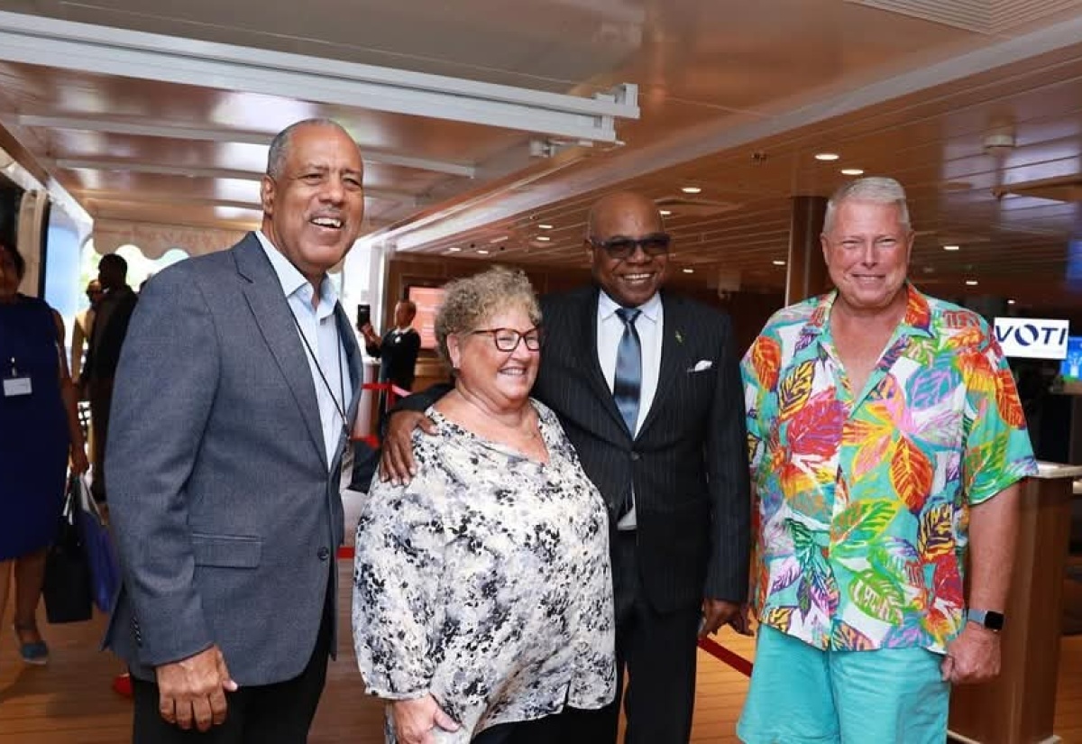 Tourism Minister, Hon. Edmund Bartlett (2nd left), and Chief Executive Officer, Port Authority of Jamaica (PAJ), Professor Gordon Shirley (left), interact with two visitors at the Port of Falmouth in Trelawny celebrating the inaugural visit of the over 3,000 passengers and crew aboard the ‘Disney Treasure’ on December 5