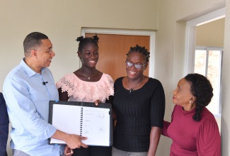 Prime Minister, Dr. the Most Hon. Andrew Holness, and Member of Parliament for St. Catherine Eastern, Denise Daley (right), share the joy of New Social Housing Programme (NSHP) beneficiary, Odenikie Smith (second left), and her daughter, Celeecia McClearie, during Thursday’s (December 5) contract signing and handover ceremony for a new $10.8 million home that was built under the initiative in St. Jago Hills, Spanish Town, St. Catherine.

