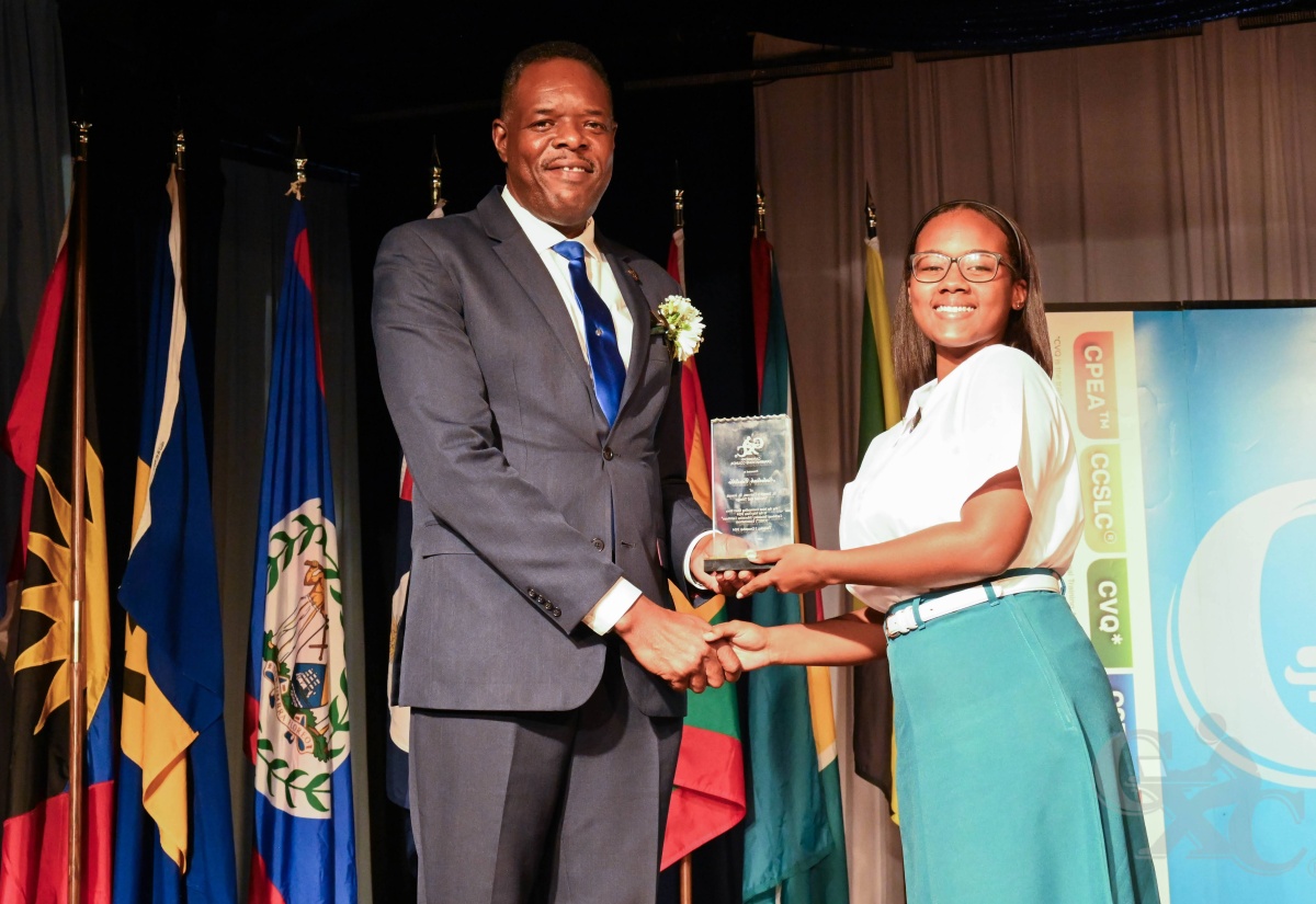 Caribbean Examinations Council (CXC) Registrar and Chief Executive Officer, Dr. Wayne Wesley (left), presents the award for Most Outstanding Caribbean Secondary Education Certificate (CSEC) Short Story to Nataliah Castillo of St Joseph’s Convent in Trinidad and Tobago, during Thursday’s (December 5) 2024 CXC Top Awards Ceremony in St. Lucia.