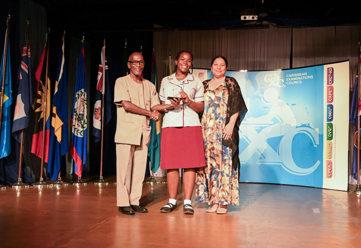 University of Guyana Registrar, Dr. Nigel Gravesande (left), and Vice Chancellor, Professor Paloma Mohamed Martin, present Shanoya Morgan of St. Andrew High School for Girls with the Menezes-Rodney Award for Most Outstanding Candidate in Caribbean Secondary Education Certificate (CSEC) History, during the Caribbean Examinations Council’s (CXC) 2024 Top Awards Ceremony in St. Lucia on Thursday (December 5).