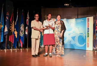 University of Guyana Registrar, Dr. Nigel Gravesande (left), and Vice Chancellor, Professor Paloma Mohamed Martin, present Shanoya Morgan of St. Andrew High School for Girls with the Menezes-Rodney Award for Most Outstanding Candidate in Caribbean Secondary Education Certificate (CSEC) History, during the Caribbean Examinations Council’s (CXC) 2024 Top Awards Ceremony in St. Lucia on Thursday (December 5). 

