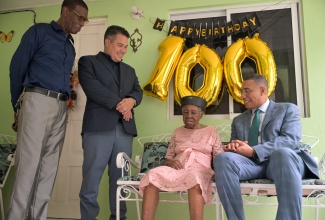 Prime Minister, Dr. the Most Hon. Andrew Holness (right), converses with centenarian, Phyllis Jamieson, during a visit to her home on Gully Road in St. Ann’s Bay, St. Ann, on November 28. Mrs. Jamieson celebrated her 100th birthday on November 16. Sharing the moment are Minister without Portfolio in the Ministry of Economic Growth and Job Creation, Hon. Matthew Samuda (second left), and Councillor for the St. Ann’s Bay Division, Dallas Dickenson.