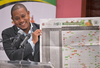 Minister of Agriculture, Fisheries and Mining, Hon. Floyd Green, shows a copy of the Ministry’s published price comparison report, during a press conference at the Ministry’s headquarters in Hope Gardens, on December 18.