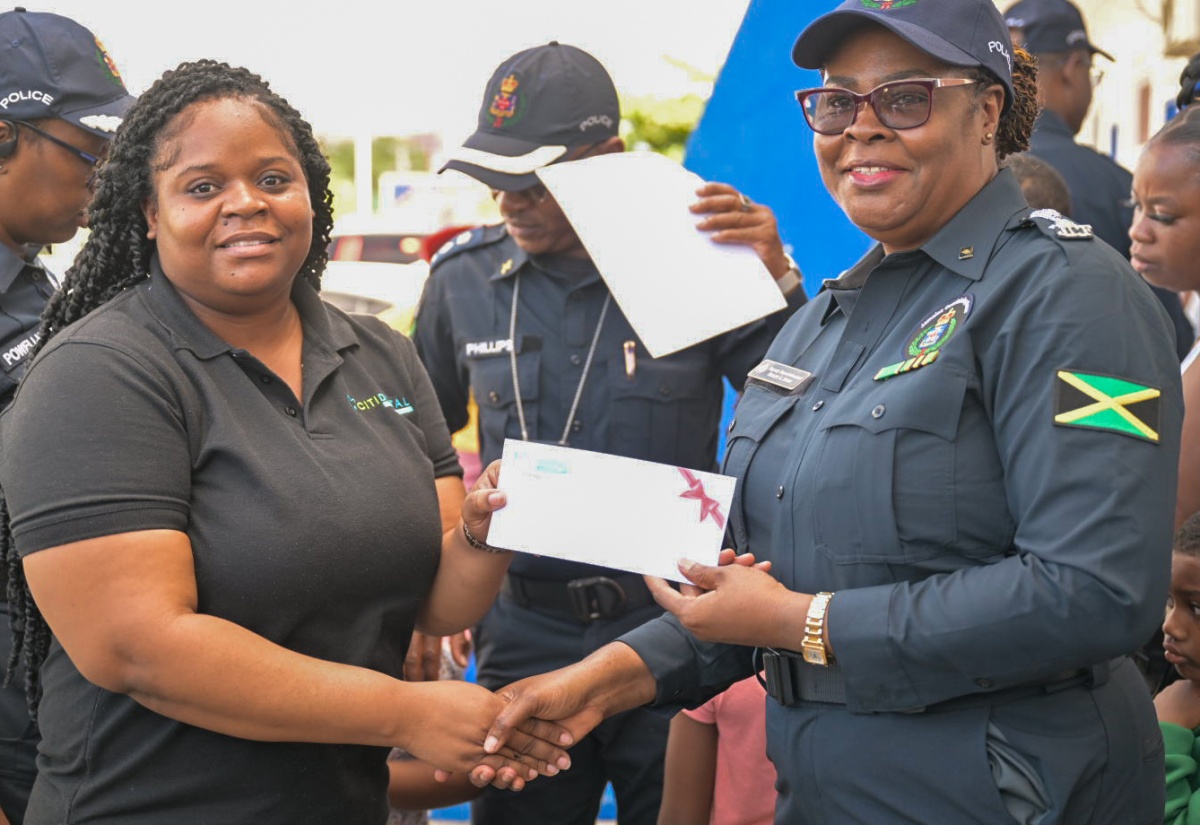 Deputy Superintendent of Police, Paulett Baker (right), receives a cheque from Manager of the Citidental and Implant Center, Venessa Morris, in support of the St. Catherine South Division’s annual Christmas initiative dubbed: ‘SHOP WITH A COP’ (SWAC) on Friday (December 20) at the Greater Portmore Police Station.