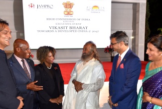 Minister of Investment, Industry and Commerce, Senator the Hon. Aubyn Hill (second left), shares a point with global humanitarian and spiritual leader, Gurudev Sri Sri Ravi Shankar (third right) at a Business and Ethics event held on Friday (December 13) on the lawns of India House, 2 East King’s House Road, Kingston. Sharing in the discussion (from left) are: Chief Executive Officer of Amber Group Limited, Dushyant Savadia; Minister of Education, Skills, Youth and Information, Senator Dr. the Hon. Dana Morris Dixon; and Indian High Commissioner to Jamaica, His Excellency Mayank Joshi and his wife, Isha Joshi.