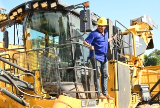 Minister of Agriculture, Fisheries and Mining, Hon. Floyd Green, inspects a mechanical harvester during a recent tour of the Frome Sugar Factory in Westmoreland.

