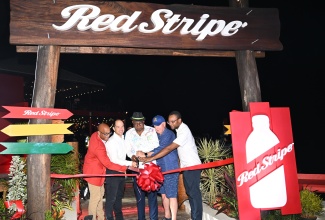 Tourism Minister, Hon. Edmund Bartlett (centre), is joined by (from left) Red Stripe’s Head of Commerce, Sean Wallace, and Managing Director, Daaf van Tilburg; Co-owner of Rick’s Café, Steve Ellman; and Member of Parliament for Westmoreland Western, Morland Wilson, in cutting the ribbon to officially launch the ‘Red Stripe Experience’ on Saturday (January 18). The launch was held at Rick