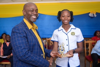 Principal of the Jose Marti Technical High School in St. Catherine, the Reverend Dr. Austin Wright (left), presents Top Sport Girl of the Year, Ashawna Sibbles with her trophy, and cash prize, during the 48th Anniversary Celebration and Founder’s Day Ceremony held at the school, on January 10.