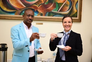 Minister of Foreign Affairs and Foreign Trade, Senator the Hon. Kamina Johnson Smith (right) shares a cup of Blue Mountain coffee with Acting Director General of the Jamaica Agricultural Commodities Regulatory Authority, Ministry of Agriculture, Fisheries and Mining, Wayne Hunter, on Thursday, (January 9) at her office to observe Jamaica Blue Mountain Coffee Day. Jamaica observes Jamaica Blue Mountain Coffee Day to honour the first shipment of coffee beans to Japan in 1953. Japan is the largest buyer of coffee beans, accounting for 70 percent of exports.