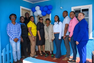 HEART/NSTA Trust Managing Director, Dr. Taneisha Ingleton (fourth right), and members of staff share a photo opportunity with homeowner Hyacinth Lowe (fifth right), and her daughter, Sharon Lowe (left), during the handover ceremony for their renovated home in Queensbury, St. Elizabeth, on Friday (January 24).

