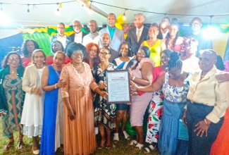 Residents of Old Harbour Bay, in St. Catherine, celebrate and display a citation in honour of fish vendors, who contributed to the development of the community centre, at the Annual Old Harbour Bay Homecoming Recognition Ceremony, held recently.