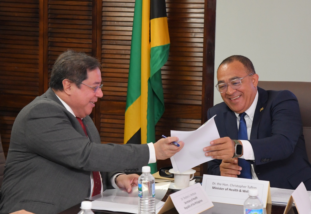 Health and Wellness Minister, Dr. the Hon. Christopher Tufton (right), shares a light moment with Secretary of Health for the Republic of the Philippines, Dr. Teodoro J. Herbosa, as they peruse a document during a meeting at the Ministry’s New Kingston offices on January 21. Dr. Herbosa is on an official visit to Jamaica.