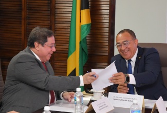 Health and Wellness Minister, Dr. the Hon. Christopher Tufton (right), shares a light moment with Secretary of Health for the Republic of the Philippines, Dr. Teodoro J. Herbosa, as they peruse a document during a meeting at the Ministry’s New Kingston offices on January 21. Dr. Herbosa is on an official visit to Jamaica.