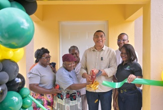 Prime Minister, Dr. the Most Hon. Andrew Holness (third right), cuts the ribbon to officially hand over a three-bedroom house under the New Social Housing Programme (NSHP) to Neita Grey (second left) in Bath Mountain , Westmoreland, on Friday (January 24). Joining them (from left) are Mrs. Grey’s daughter, Sonia Grey-Royal; Chairperson of the NSHP Oversight Committee, Judith Robb Walters; Member of Parliament for Western Westmoreland, Morland Wilson; and Permanent Secretary in the Ministry of Economic Growth and Job Creation, Arlene Williams. Mrs. Grey received one of four homes handed over in Westmoreland by the Prime Minister on the day.

