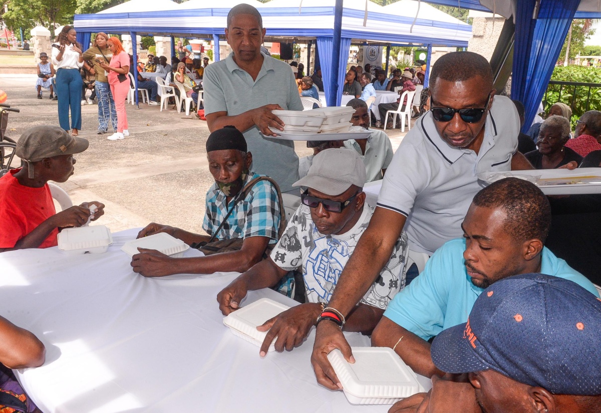 Mayor of Kingston, Councillor Andrew Swaby (third right), and Deputy Mayor of Kingston and Councillor for the Seivwright Gardens Division, Delroy Williams (second left), serve lunches during the Mayor’s annual New Year’s Day Feeding of the Homeless on New Year’s Day, January 1, 2025, at St. William Grant Park in downtown Kingston.