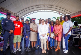 Custos of Clarendon, Edith Chin (centre), shares a moment with members of the police force and other stakeholders, during a recent treat for children at The Verandah at the Juici Empowerment Park in Clarendon.
