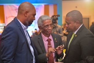 Minister of Agriculture, Fisheries and Mining, Hon. Floyd Green (right), and Chairman, Jamaica Stock Exchange (JSE), Steven Whittingham (left), in discussion with Chairman, Jamaica Social Stock Exchange (JSSE), Professor Neville Ying, during the 20th JSE Investments and Capital Markets Conference, held recently at The Jamaica Pegasus hotel in New Kingston.

