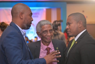 Minister of Agriculture, Fisheries and Mining, Hon. Floyd Green (right), converses with Chairman, Jamaica Stock Exchange (JSE), Steven Whittingham (left), and Chairman, Jamaica Social Stock Exchange (JSSE), Professor Neville Ying, during the 20th JSE Investments and Capital Markets Conference at the Jamaica Pegasus Hotel in New Kingston on Thursday (January 23).

