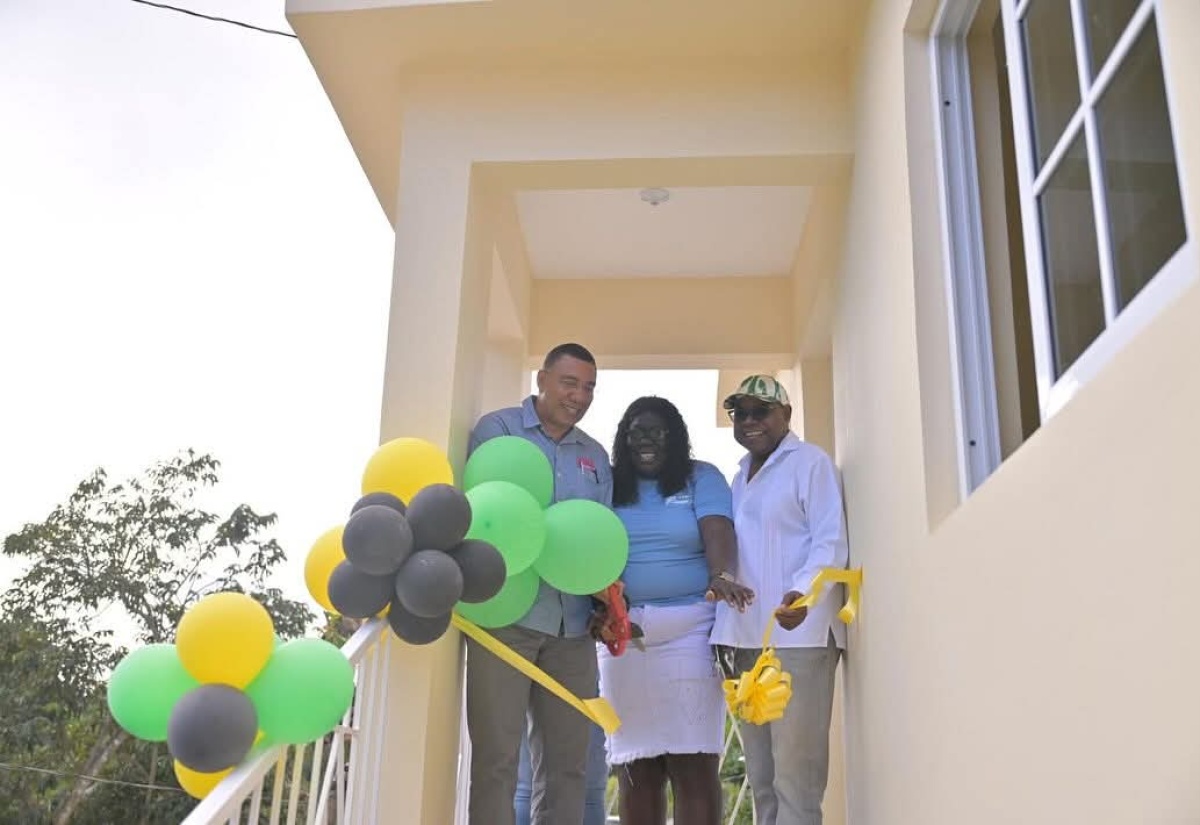 Prime Minister, Dr. the Most Hon. Andrew Holness (left), celebrates with New Social Housing Programme (NSHP) beneficiary, Veronica Innis, during the handover of a unit that was built for her in Somerton, St. James East Central, on Friday (January 17). Sharing the moment is Tourism Minister and Member of Parliament for the constituency, Hon. Edmund Bartlett.