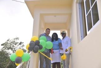 Prime Minister, Dr. the Most Hon. Andrew Holness (left), celebrates with New Social Housing Programme (NSHP) beneficiary, Veronica Innis, during the handover of a unit that was built for her in Somerton, St. James East Central, on Friday (January 17). Sharing the moment is Tourism Minister and Member of Parliament for the constituency, Hon. Edmund Bartlett.