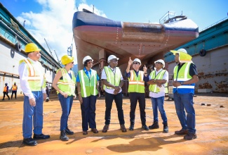 Minister of Labour and Social Security (MLSS), Hon. Pearnel Charles Jr. (centre), having a conversation with Chief Executive Officer of German Ship Repair Jamaica (GSRJ), Colonel Martin Rickman (third right), during a tour of GSRJ